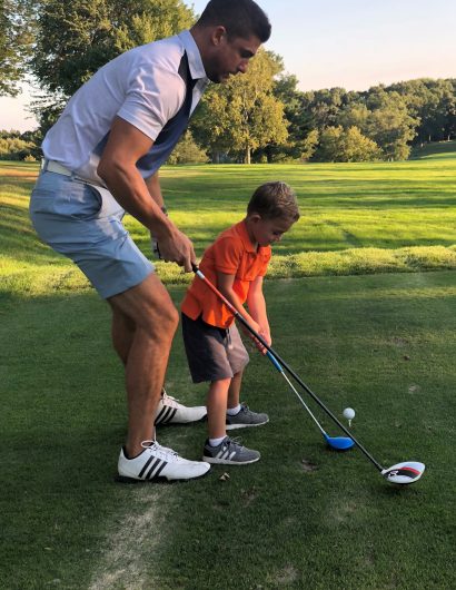 Photo of Evan and his son golfing