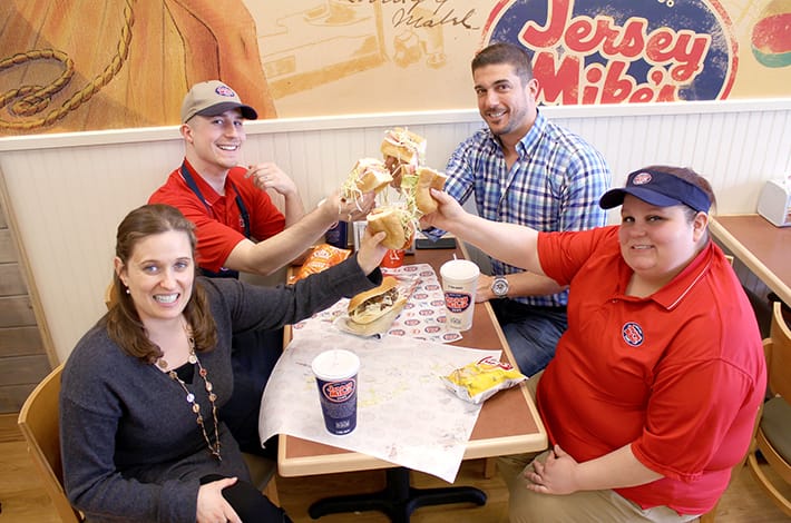 linear team eating sandwiches at jersey mikes